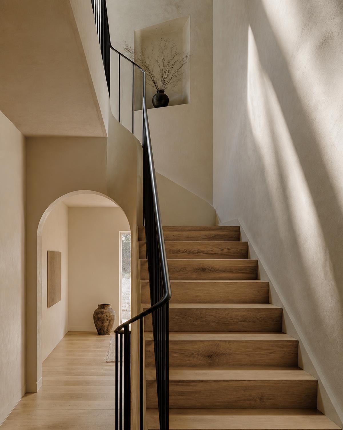 White oak stair with a blackened steel railing against warm plaster walls